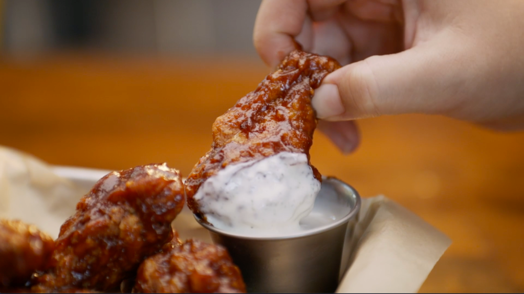 hoots wings franchise wing dipped in sauce 